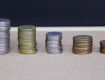 Stacks of coins arranged in ascending order on a wooden surface