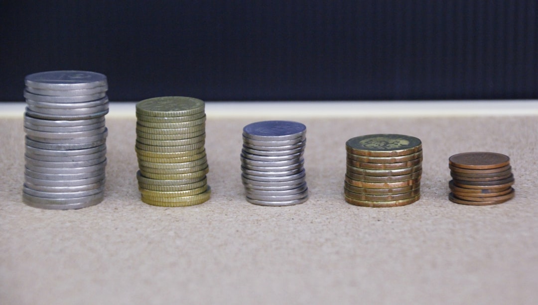 Stacks of coins arranged in ascending order on a wooden surface