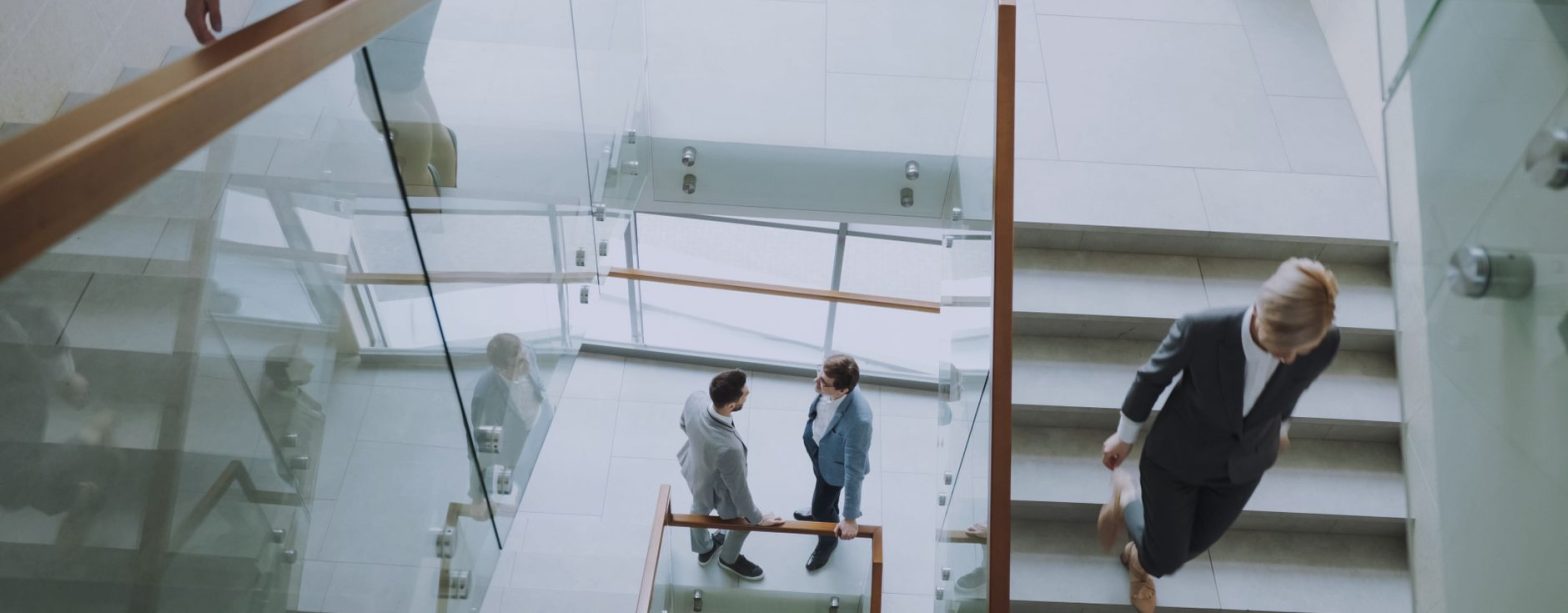 Aerial view of professionals conversing in a glass staircase in a modern office. — Connect With a Mortgage Lender Jacksonvill