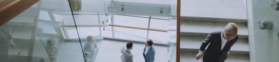 Aerial view of professionals conversing in a glass staircase in a modern office. — Connect With a Mortgage Lender Jacksonvill