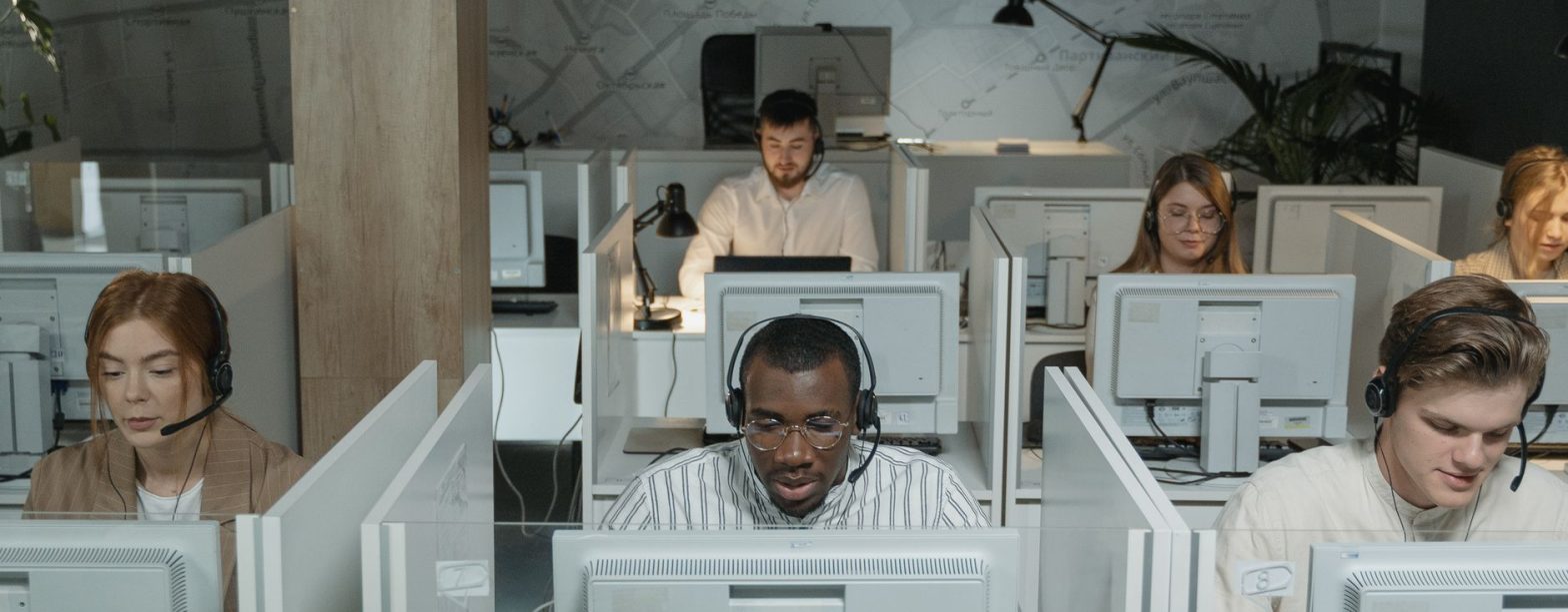A diverse group of call center agents working in an organized office setting, focused on assisting customers. — Prop Trading