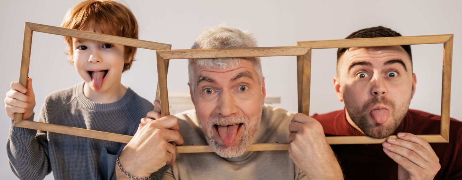 Grandfather, father, and son making funny faces indoors with wooden frames. — Why Are Prostitutes Verified on MissDnepr?