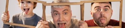 Grandfather, father, and son making funny faces indoors with wooden frames. — Why Are Prostitutes Verified on MissDnepr?